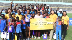 Minister of Culture, Gender, Entertainment and Sports, the Honourable Olivia Grange along with Devon Biscuits brand manager Sherene Bryan presented the INSPORTS/Devon Biscuits National Primary schools winning trophy to champions Lyssons Primary school. 