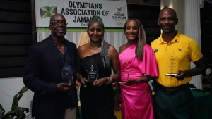 Honoured Jamaica Olympians (l-r) Winthrop Graham, Debbie Byfield-Russell, Brigitte Foster-Hylton and Ian Weakly with their trophies at the Alhambra Inn in Kingston on Tuesday night.