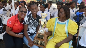 Hydel High School&#039;s star athlete Alana Reid with the winners trophy with Grace Burnett CEO and President of the GraceKennedy Financial Group and school founder Hyacinth Bennett on Monday as the school celebrated winning the Girls&#039; title at the 2023 ISSA GraceKennedy Boys and Girls Championships