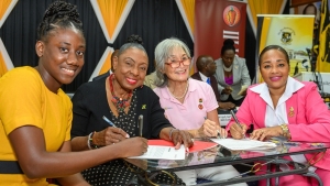 Alexis James (left) beams after signing her sponsorship agreement that was witnessed by Jamaica’s Sports Minister Olivia Grange (second left). Dr Thalia Lyn, founder of Island Grill and Chairperson of the NCB Foundation and Tanya Waldron-Gooden, CEO of Island Grill signees to the agreement share in the occasion.