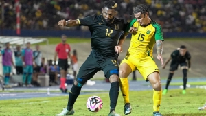 Reggae Boy Joel Latibeaudiere (right) challenges Jorge Benguche of Honduras for possession.