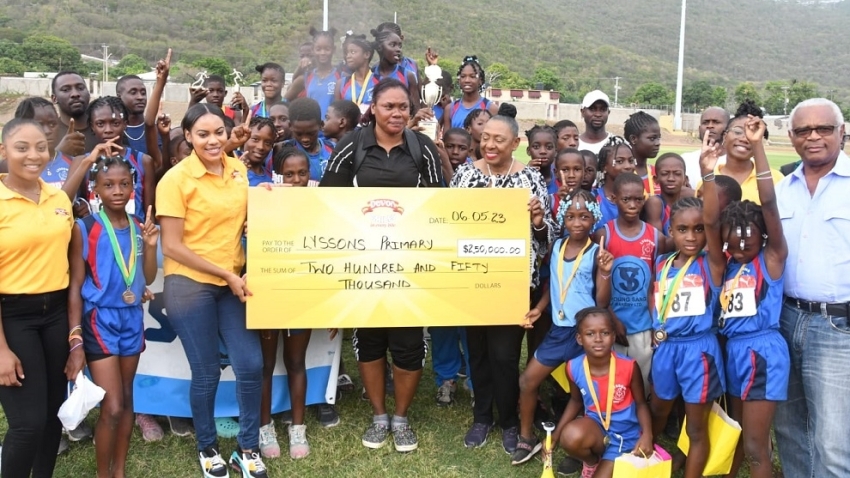 Sherene Bryan Brand manager of Devon Biscuits (left) presents the winning cheque to winning coach Lesia Jackson of Lyssons (centre) while Minister of Sports Olivia Grange shares in the occasion. 