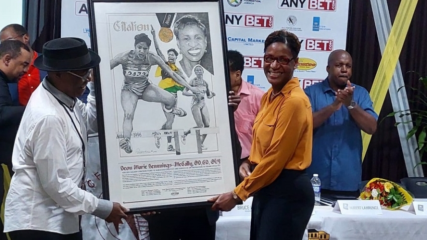 Deon Hemmings-McCatty, the first Jamaican woman to win an Olympic gold medal receiving a citation from artist Patrick Kitson during the launch of the book 50 Days Afire at the GC Foster College in Spanish Town, St Catherine on Thursday night. Hemmings-McCatty won the 400m hurdles at the 1996 Olympic Games in Atlanta in an Olympic record 52.82s.