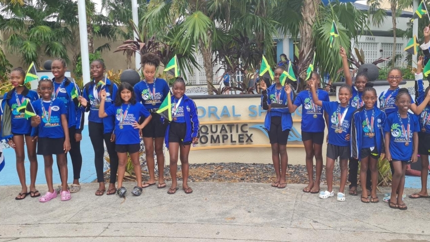 Members of the Island Aquatics Synchro club proudly display the country&#039;s flag following their performance at the World Invitational Meet in Coral Springs, Florida,  recently.