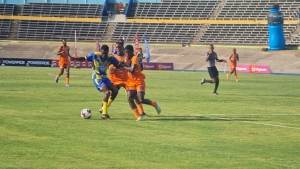 Clarendon College&#039;s Kahiem Dixon (left) fends off a challenge from Lennon&#039;s Teancom Simpson during their ISSA/WATA daCosta Cup opening contest at the National Stadium on Saturday. 
