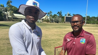 Joshua Bishop receiving the Player of the Match award from Junie Mitcham of CWI.