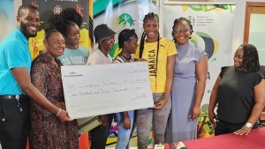 From r-l: Netball Jamaica President Tricia Robinson, Sandrina Davis, CEO of the Grace and Staff Community Foundation, Latanya Wilson and her sisters and mother, Minister of Sport Olivia Grange and Daniel Jarrett of GraceKennedy as the foundation handed over a cheque of $250,000 to the netball player and her family at Jamaica&#039;s Ministry of Culture, Gender, Sports and Entertainment in Kingston on Wednesday.