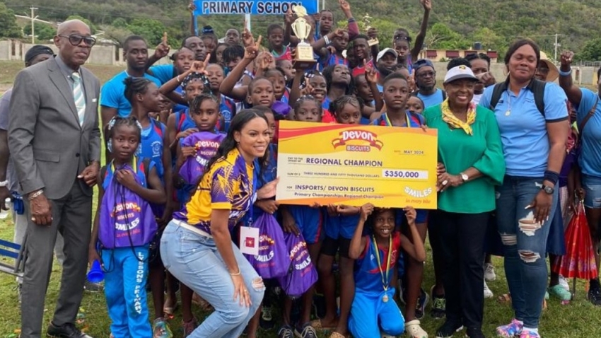 Minister of Sports Olivia Grange (green top) and Devon Biscuits brand manager, Sherene Bryan (stooping) present the symbolic cheque to Lyssons Primary. At left Ian Forbes, Chairman of INSPORTS.