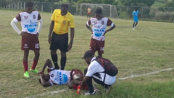 Kellits High players look on as a teammate gets treated during a recent DaCosta Cup game.