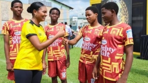 Kristina Hill (second left), brand manager, beverages, Grace Foods, greets members of the Wolmer’s Boys’ under-16 team.