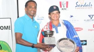 Evan Pena of Puerto Rico receives the James Moss Solomon championship trophy from Dr. Carey Wallace, CEO of TEF at the 36th Caribbean Amateur Junior Golf Championship recently.