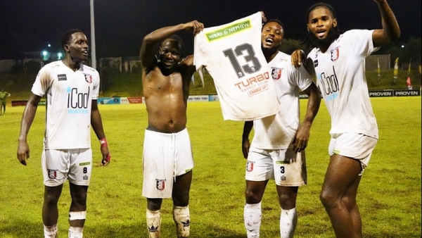 Marlon Martin (left), Shane Watson (second right) and Joel Jones (right) celebrate with Fabian Reid who displayed his #13 jersey after scoring his 80th goal in the Wray and Nephew Jamaica Premier League at Stadium East Field on February 5.