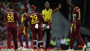 Andre Russell celebrates one of his three wickets with teammates.