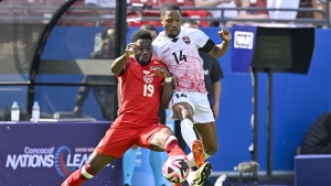 Trindad and Tobago&#039;s Shannon Gomez (right) challenges Canada&#039;s Alphanso Davies for possession.
