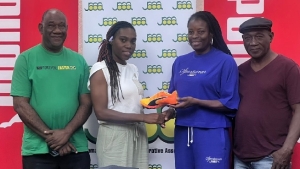 Garvey Maceo&#039;s coach Tatiana Smith collecting competition spikes from Campbell while Dennis May (left) and a member of the Garvey Maceo coaching staff look on.