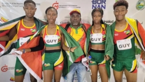 (From left) Malachi Austin, Narissa McPherson, Tianna Springer and Javon Roberts share a photo opportunity with coach Julian Edmonds after setting a new 4x400m Mixed Relays record at the Commonwealth Youth Games in Trinidad and Tobago on Thursday.